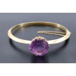 An impressive late 19th / early 20th Century amethyst and high carat yellow metal hinged bangle, the
