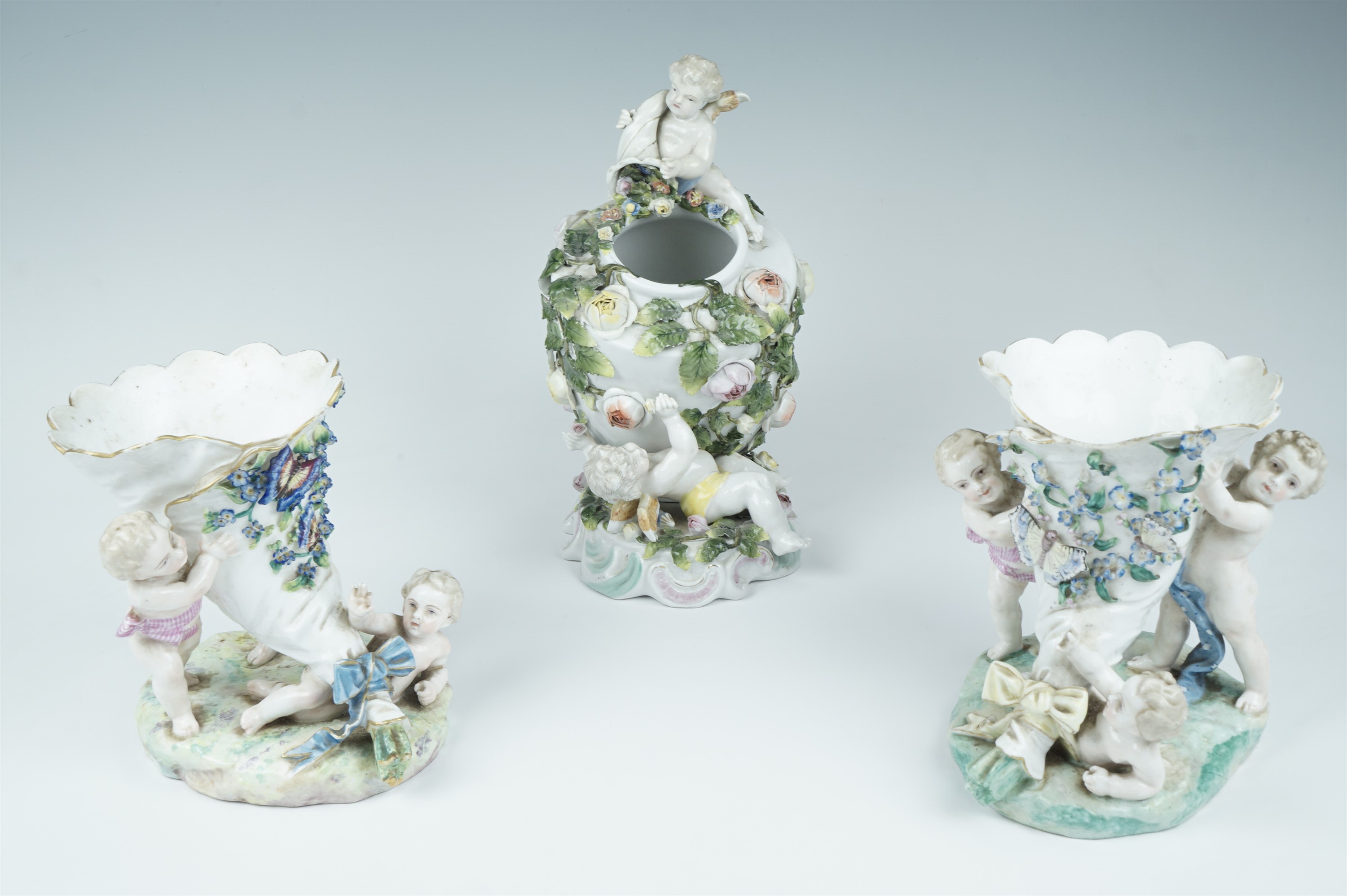 A late 19th Century German figural vase, an urn covered with trailing roses and attended to by - Image 2 of 2