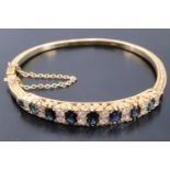 A striking diamond and sapphire 18 ct gold bracelet, nine graduated oval sapphires (approximately