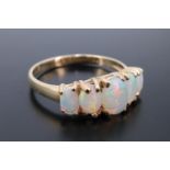 A five stone opal ring, comprising five graded oval cabochons, the central stone 7 mm x 5 mm, claw