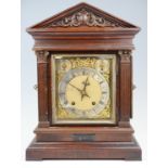 An early 20th Century German scumbled walnut mantle clock, striking and chiming on gongs, in an