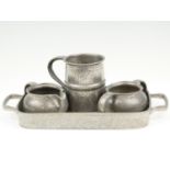 A group of Tudric pewter comprising a small tray, 32 cm x 15 cm, together with a sugar bowl, a cream
