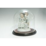 An early 20th Century Continental bisque figure group, modelled as a boy and girl with an