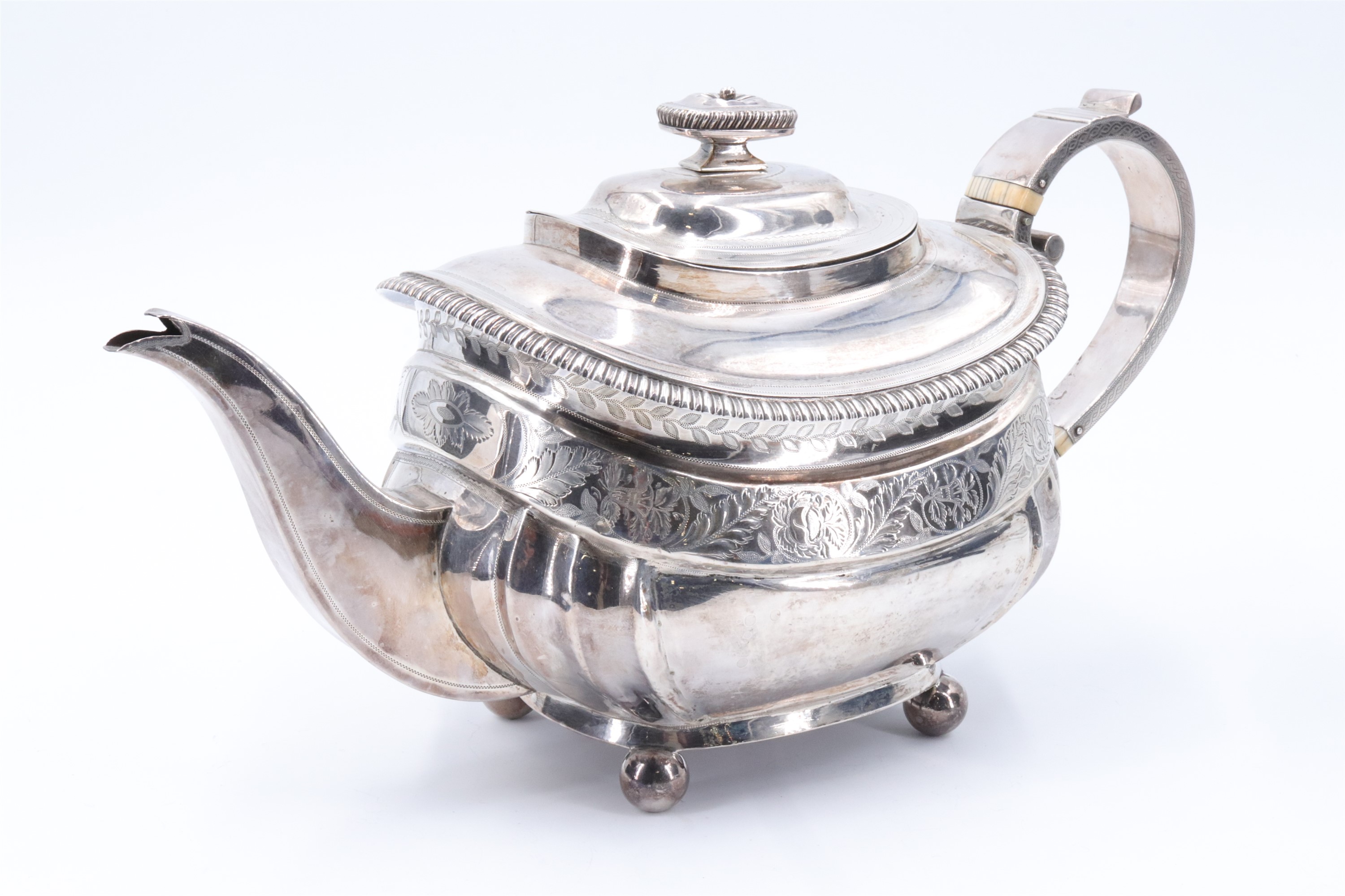 A George III silver teapot, having a square section spout, strap form handle with ivory