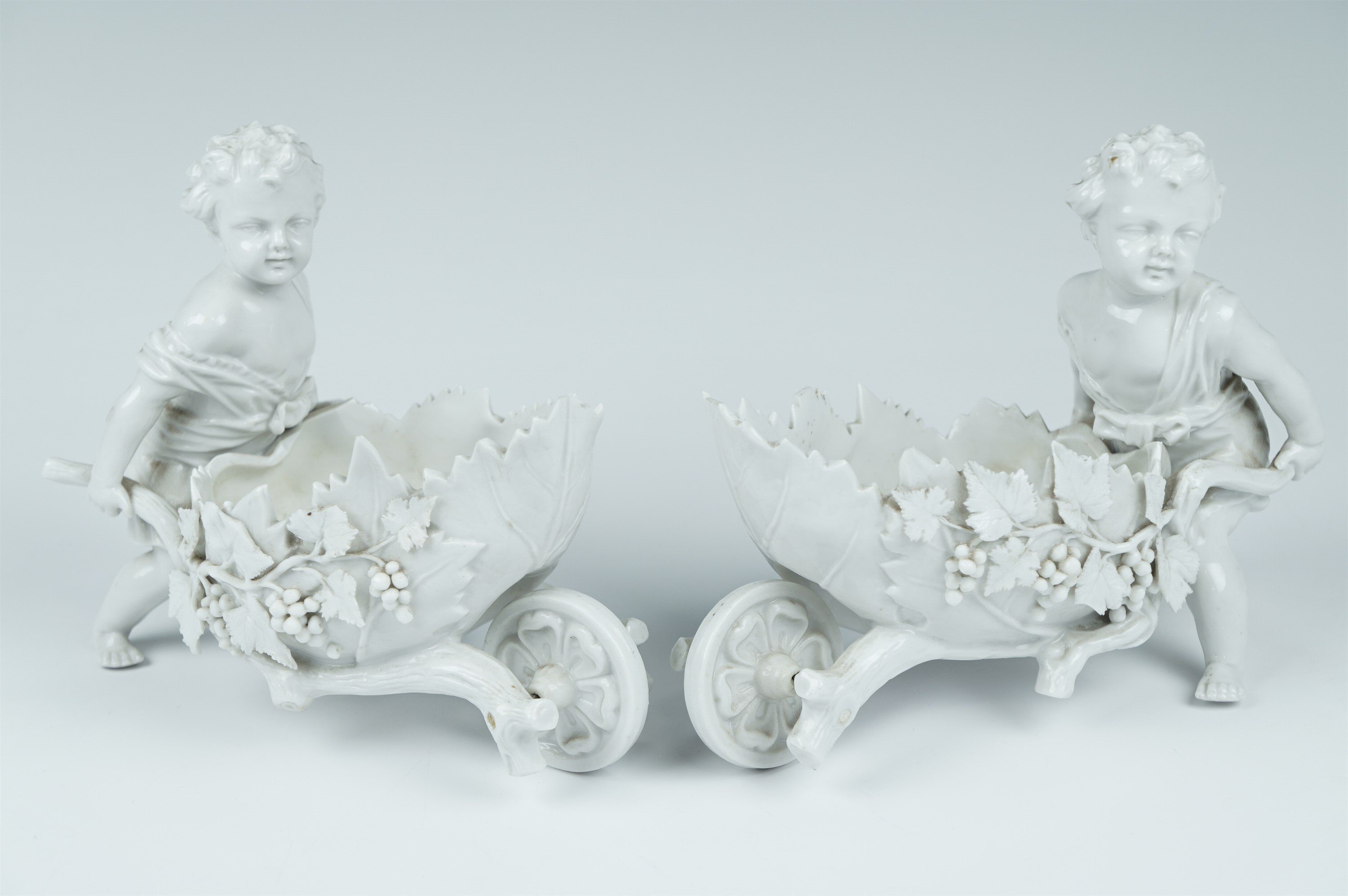 A pair of late 19th Century Volkstedt blanc de chine articulated porcelain figures of putti