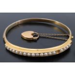 A pearl and high carat yellow metal hinged bangle, the D-section bangle faced with line-set pearls