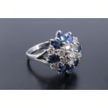 A cluster set diamond and sapphire ring, being three terraces of stones, a central 3 mm brilliant