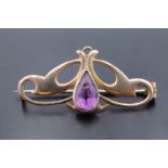 A late 19th / early 20th Century Art Nouveau amethyst and yellow metal brooch, set with a pendeloque