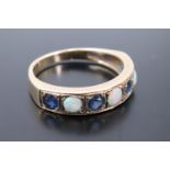 An opal and sapphire half hoop ring, comprising opal cabochons divided by round cut sapphires