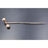 A late 19th / early 20th Century yellow metal stick pin having a barbell terminal, 5.5 cm, 1.0 g