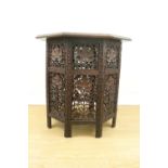 An Indian carved hardwood octagonal folding table, 52 cm x 56 cm