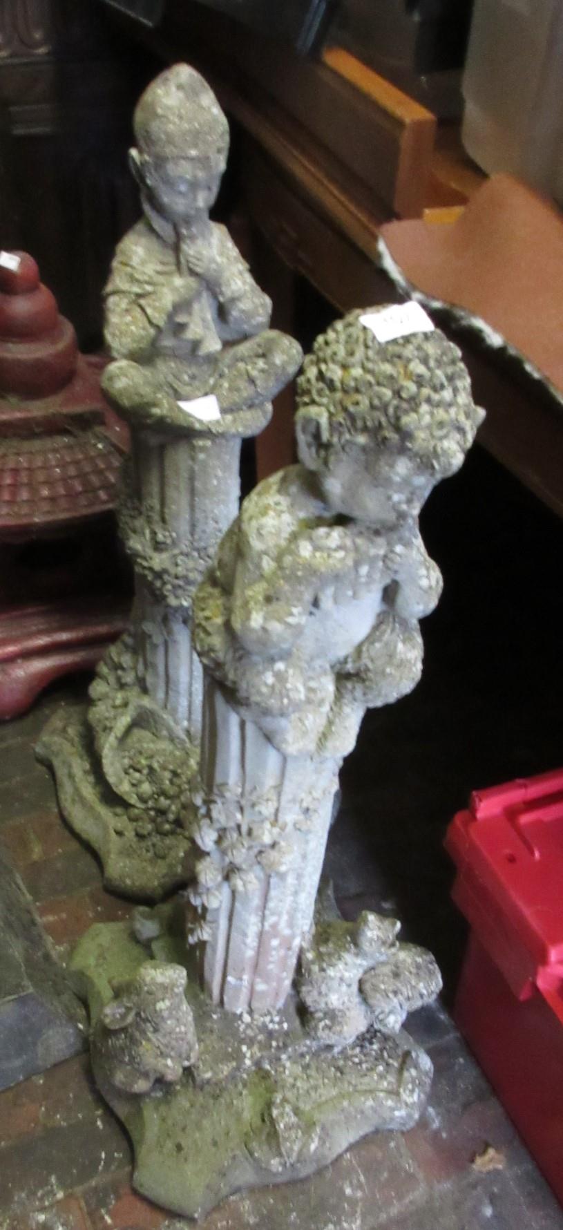Two 20th Century weathered cast concrete ornamental columns, mounted with figures of a faun and