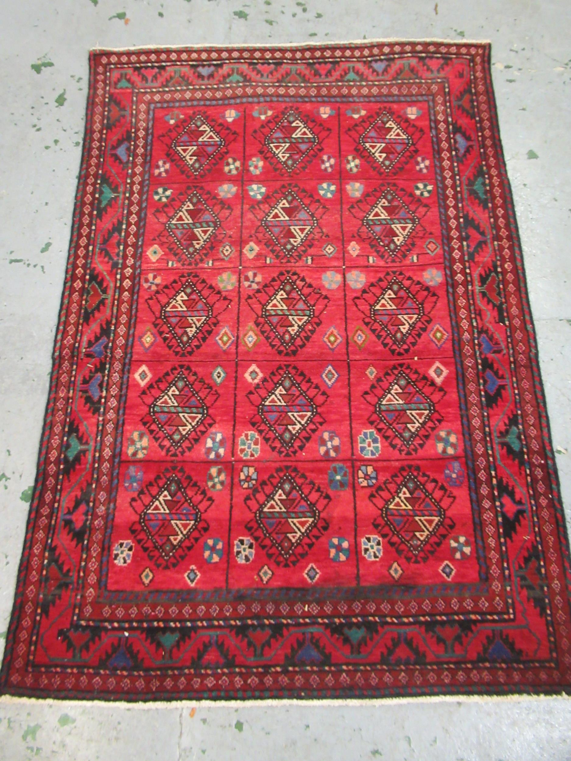 Modern Belouch style rug with an all over hooked medallion and panel design on a red ground with