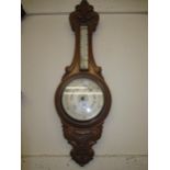 Early 20th Century carved oak aneroid barometer thermometer with silvered dials (thermometer at