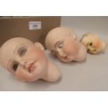 Two bisque dolls heads, together with another (at fault)