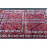 Turkoman rug with a four panel design in dark shades on a wine red ground, 6ft 8ins x 4ft 4ins