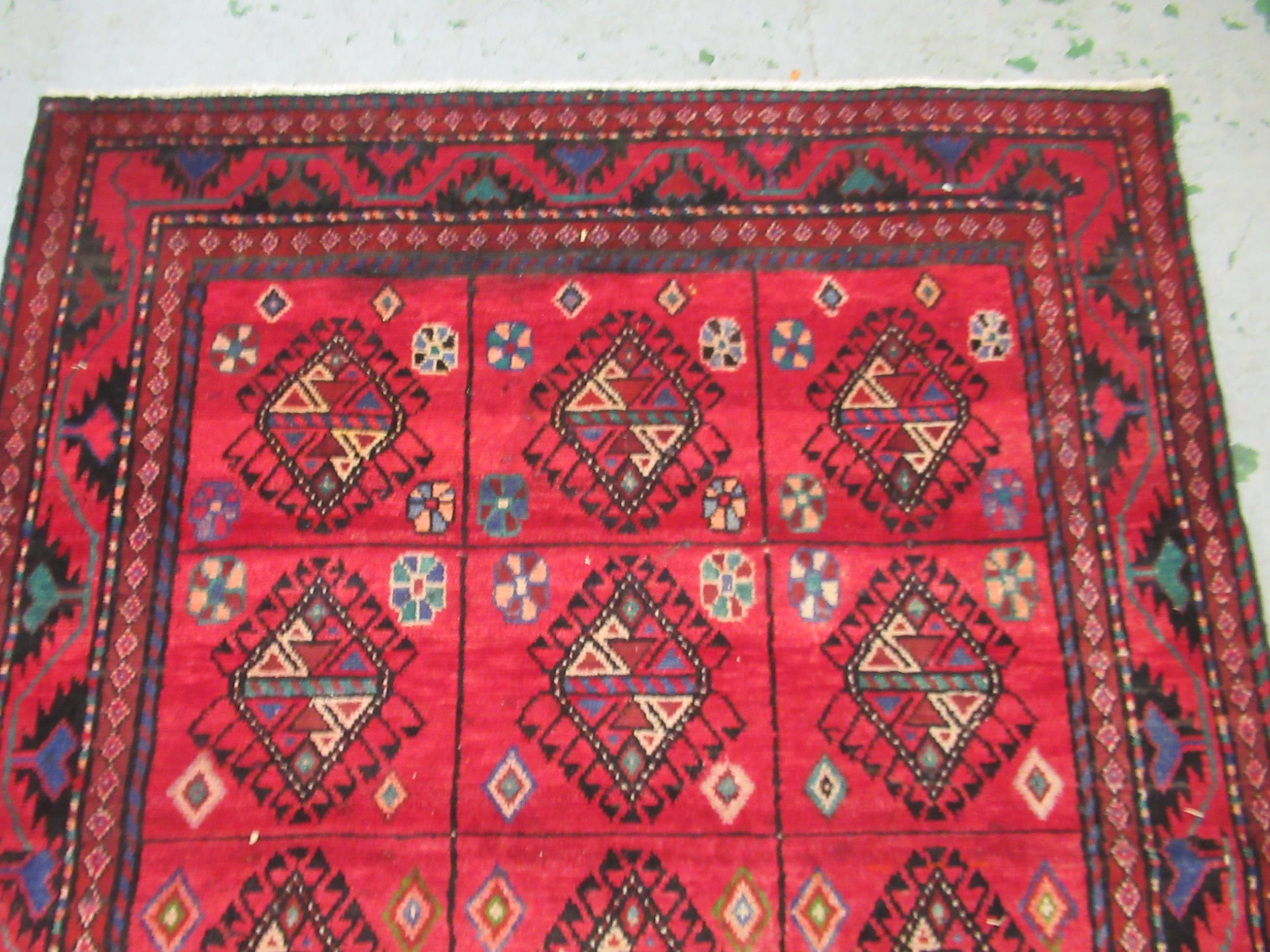 Modern Belouch style rug with an all over hooked medallion and panel design on a red ground with - Image 3 of 5