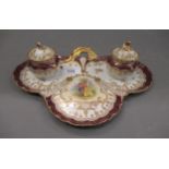 Dresden porcelain two bottle inkstand painted with figures in a garden within gilded borders Some