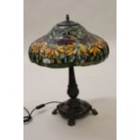 Reproduction Tiffany style table lamp, the leaded glass floral design shade above a dark patinated