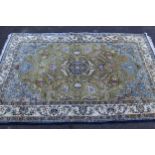 Indo Persian rug with a medallion and all-over stylised floral design on a pale green ground with