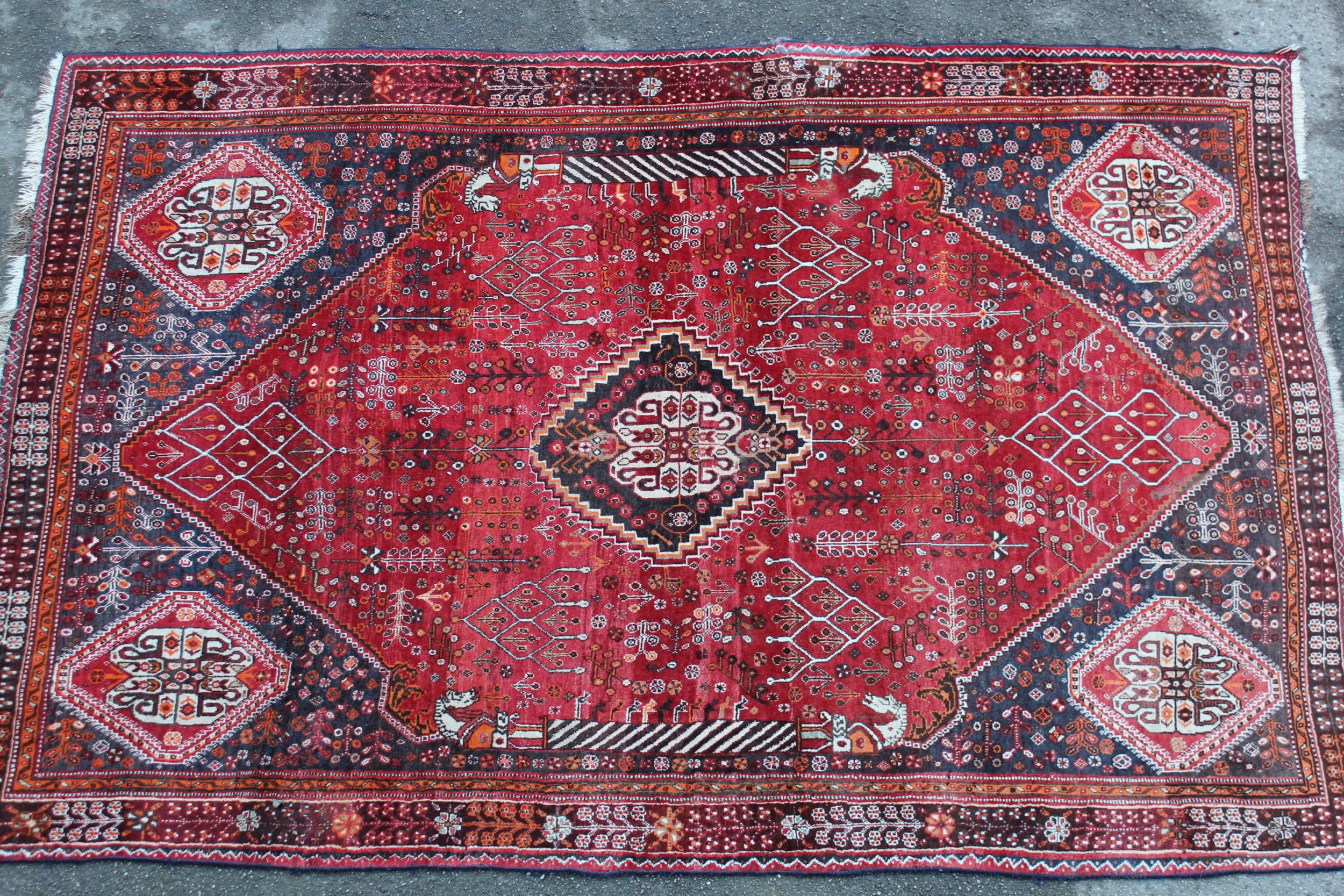 Qashqai rug with central medallion design on red and blue ground with borders, 96ins x 64ins Good