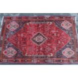 Qashqai rug with central medallion design on red and blue ground with borders, 96ins x 64ins Good