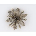 Diamond set flower head brooch, (centre stone lacking)