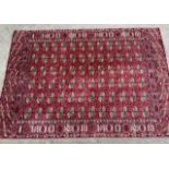 Machine woven carpet of Turkoman design with six rows of gols on wine ground with borders, 11ft 4ins