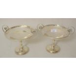 Pair of Edwardian silver two handled pedestal bonbon stands, each with a pierced rim, scroll