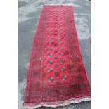 Afghan runner with two rows of gols on a red ground with borders, 9ft 6ins x 2ft 10ins approximately