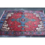 Turkish rug with a lobed medallion and all-over stylised floral design on a red ground with blue