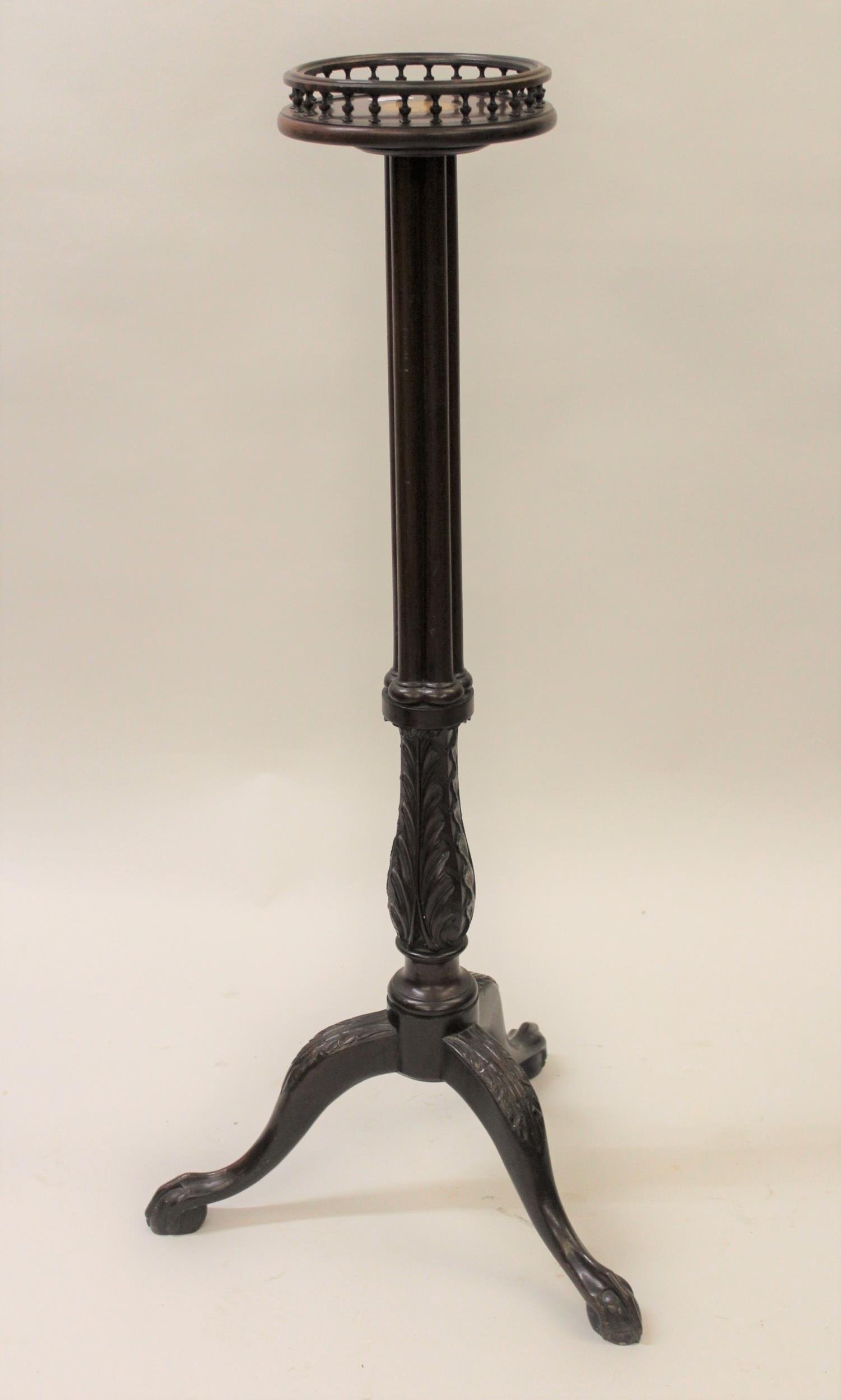 Reproduction mahogany torchere with a galleried top above a cluster column support and tripod base