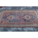 Small Qashqai rug with a triple repeating medallion design on a midnight blue ground with corner