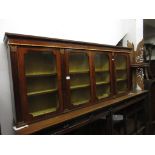 Rosewood and parcel gilt wall cabinet in Regency style, the moulded cornice above two pairs of