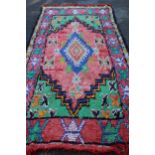 Berber rug of polychrome medallion design with rose ground, 11ft 6ins x 5ft 4ins approximately