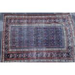 Shirvan rug with blue ground repeating rosette centre panel and multiple borders (various areas of