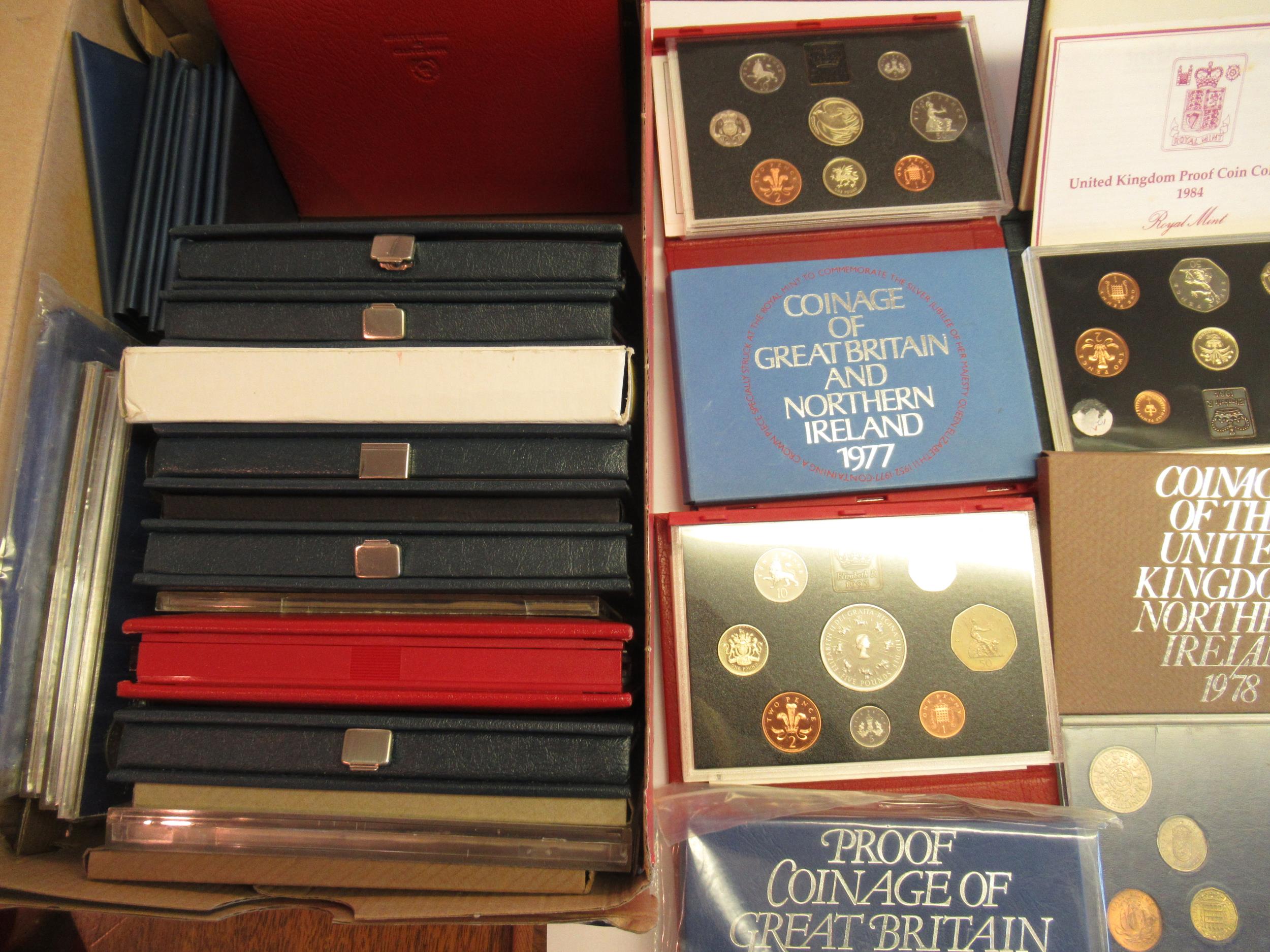 Box containing a collection of cased and boxed GB coin sets