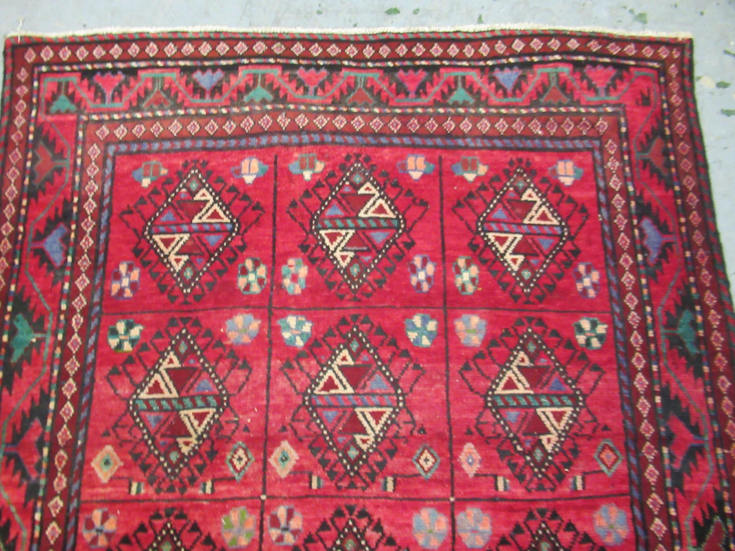 Modern Belouch style rug with an all over hooked medallion and panel design on a red ground with - Image 2 of 5