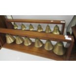Two mahogany brackets housing a set of twelve various tuned bells