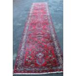 Sarouk runner with a typical all-over floral design on a red ground with border, 17ft 8ins x 3ft