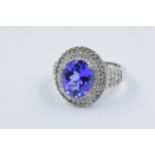 18ct White gold ring set with large oval tanzanite surrounded with a double band of round