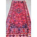 Shiraz runner with a medallion and all-over stylised flowerhead design on a red ground with borders,