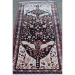 Modern Belouch rug with an all-over stylised animal, bird and floral design on a dark ground with