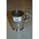 Small George II silver mug of baluster form with a scroll handle and later chased floral decoration,