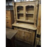 19th Century stripped pine dresser, the moulded top above a pair of glazed doors and an alcove