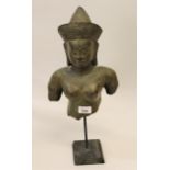 Southeast Asian patinated metal bust mounted on a wooden stand, 18ins high