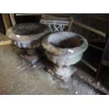 Pair of weathered cast concrete pedestal garden urns of circular fluted design, 16ins x 19ins