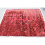 Afghan rug with two rows of five gols on a wine red ground with borders, 5ft 8ins x 4ft 6ins