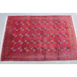 20th Century Turkoman carpet with five rows of gols on a wine red ground with borders, 11ft x 7ft