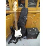 Squier Stratocaster guitar, together with a Peavey practice amplifier, guitar stand etc.